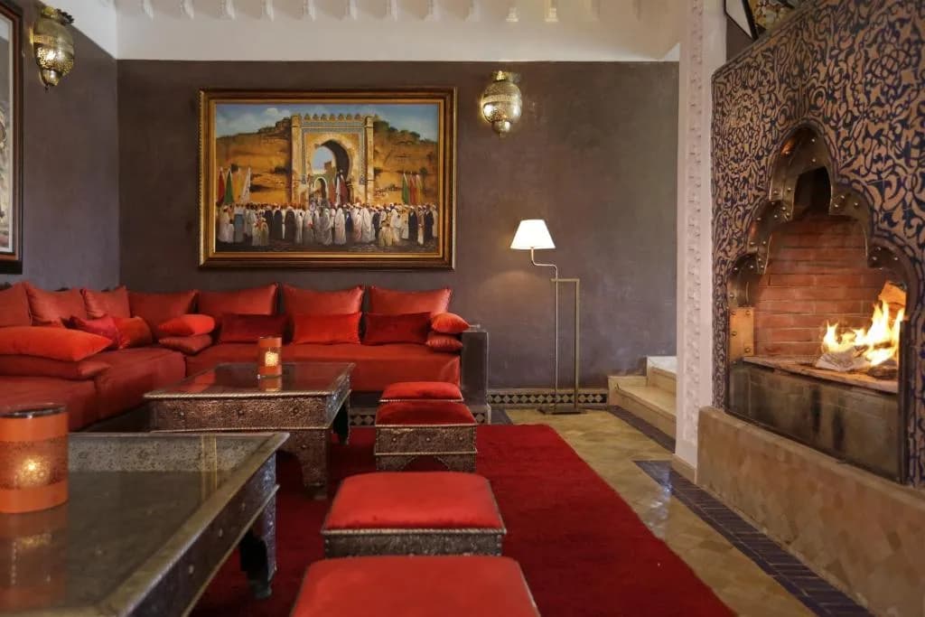 Salon marocain de la Villa Grace, banquettes rouges et cheminée en mosaïque
